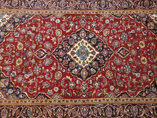 tapis iranien noué main kechan fond rouge et medaillon central