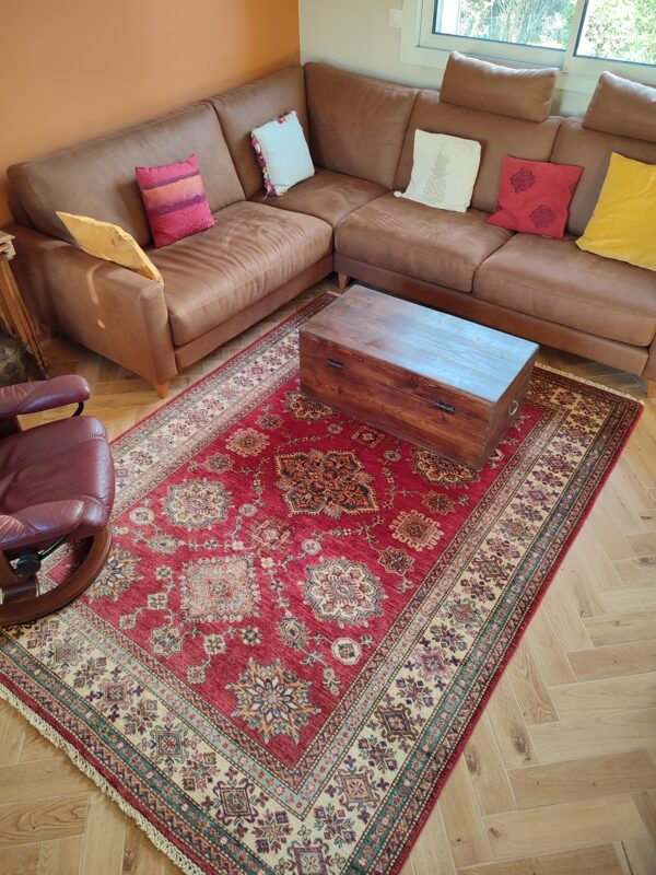 Structurer un salon chaleureux avec un tapis Kazak rouge profond 1