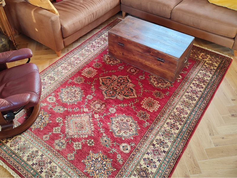Structurer un salon chaleureux avec un tapis Kazak rouge profond