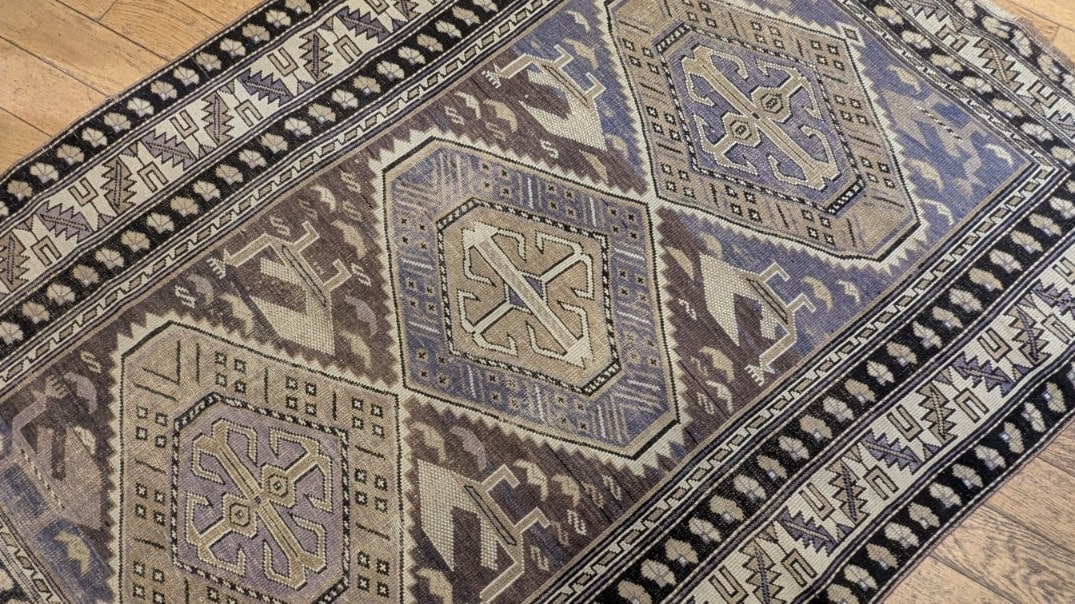 Nuances abrash brunes et ocre sur un tapis tribal noué main