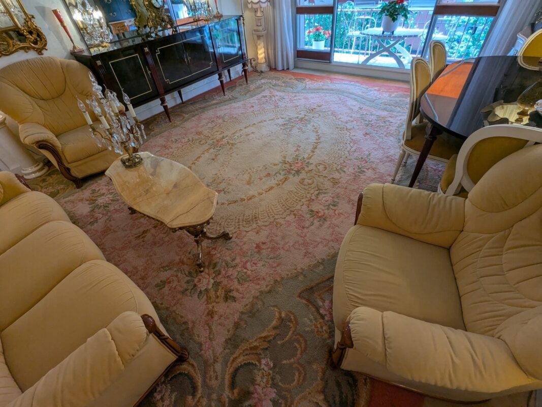Grand tapis d'Aubusson aux motifs floraux pastel dans un salon parisien, en situation