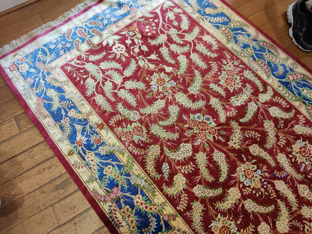 Tapis Ghoum en soie à fond rouge, rameaux fleuris en semis et bordure de cyprès, collection Tapis Bouznah