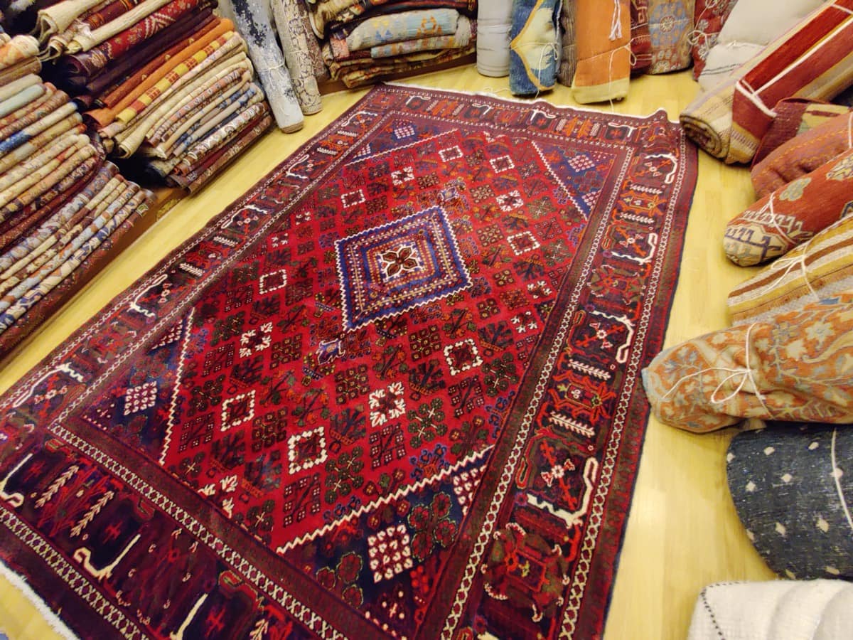 Tapis Meymeh à treillis géométrique de losanges fleuris et médaillon central à gradins sur fond rouge, collection Tapis Bouznah