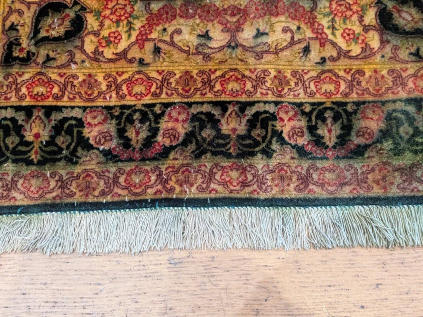 Bordure d'un tapis persan noué main aux teintures naturelles rouge, bleu et or, collection Tapis Bouznah